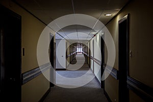 Dark hotel lobby with rooms on both sides of the corridor taken in a 70`s designed hotel.