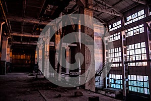 Dark industrial interior of large empty hall for manufacturing or warehousing. Abandoned factory