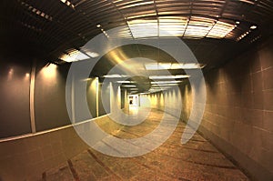 Dark interior of the underground passage with electric lighting