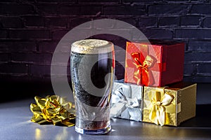 A dark Irish dry stout beer glass with a gift boxes