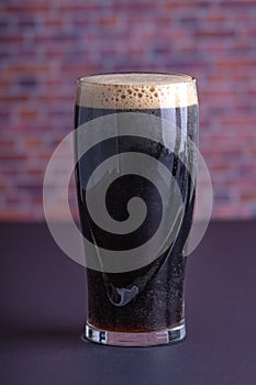 A dark Irish dry stout beer glass that originated in the brewery in dublin