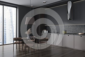 Dark kitchen interior with seats and eating table, panoramic window