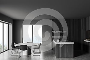 Grey kitchen interior with chairs and table, cooking area and panoramic window