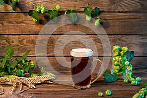 Dark lager beer glass, brown ale on wooden table in bar or pub