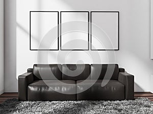 Dark leather couch with three canvases on white wall. Living room seating