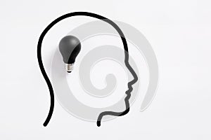 Dark light bulb inside human head profile representing ignorance and lack of ideas photo