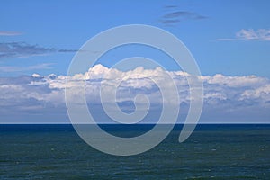 DARK AND LIGHT LAYERED WATER IN THE INDIAN OCEAN WITH CLOUDS ON THE HORIZON