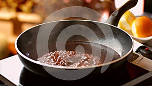 Dark liquid boiling on pan.