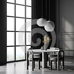 Dark living room interior with panoramic window, table, and chairs