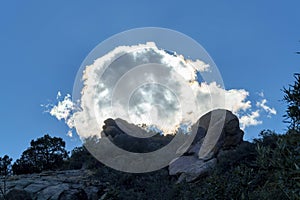 Dark looming ominous clouds in the hills of arizona mountains with dark blue sky and sillhouette trees and rock ravines