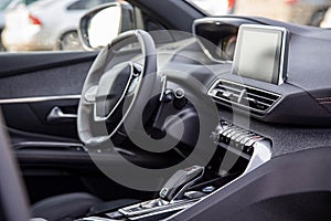Dark luxury car interior. Black leather multifunctional steering wheel, start and stop engine buttom, dashboard