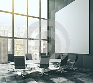 Dark meeting room with blank picture frame and table