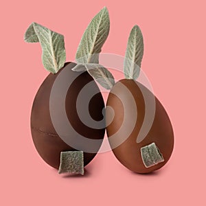 Dark and milk chocolate Easter bunnies over pink background,  creative art concept, close up