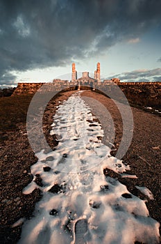 Dark and moody photo of Cairn of General Milan Rastislav Stefanik with snow covered path on sunset in Brezova pod Bradlom town.