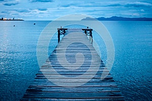 Dark morning by the sea. Pier in storm. Solitude, Loneliness concept photo