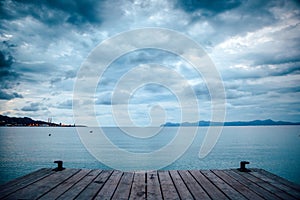 Dark morning by the sea. Pier in storm. Solitude, Loneliness concept photo