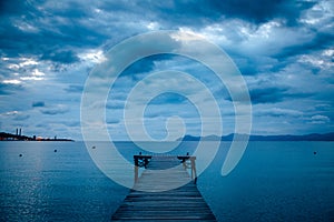 Dark morning by the sea. Pier in storm. Solitude, Loneliness concept photo
