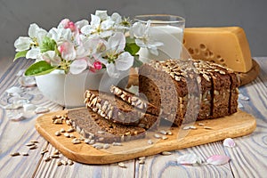 Dark multigrain bread made from rye, wheat, oats and barley with sunflower and flax seeds. Milk, cheese, apple tree flowers and