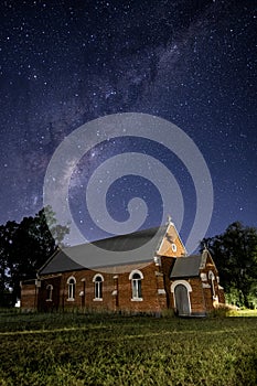 In the dark of the night a church situated under the milky way sky