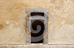 A dark and old rectangle entrance without door in a stone wall