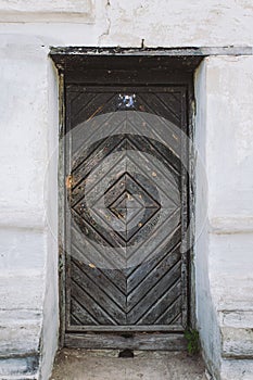 Dark old vintage wooden door with rusty metal handle