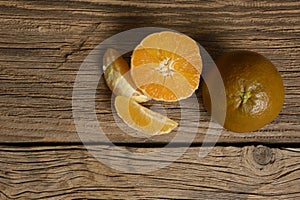 Dark orange isolated on wooden background. Brown oranges