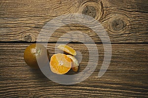Dark orange isolated on wooden background. Brown oranges