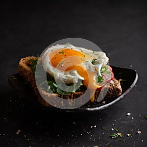 Dark photo of sandwich with fryied egg