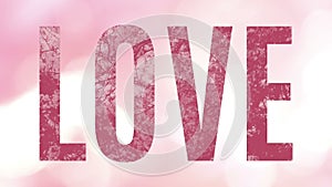 Dark pink word Love animated showing rotating flowering bushes, over a soft pink and bright background with bokeh lights.