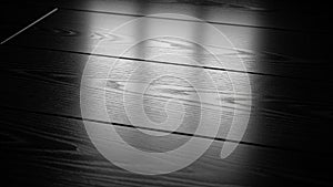 Dark polished wood floor with dramatic light and shadow patterns