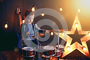 Dark portrait of Beautiful boy playing the drums on a black background with smoke