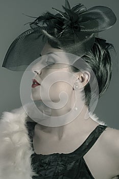 Dark portrait of a beautiful young widow dressed in a haute couture black outfit during a funeral service