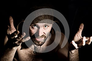 Dark portrait of scary evil sinister bearded man with smirk, makes various hand's signs and expresses different emotions