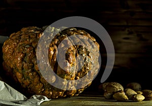 Dark pumpkin on a table with walnuts