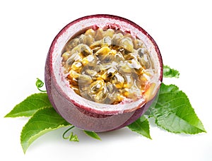 Dark purple passion fruit half with seedy interior laying on green passiflora leaves on white background