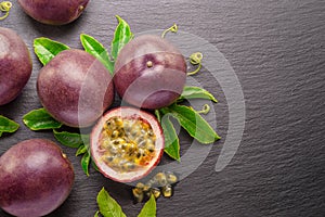 Dark purple passion fruits and half of maracuya fruit isolated on slate graphite gray background