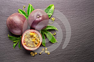 Dark purple passion fruits and half of maracuya fruit isolated on slate graphite gray background