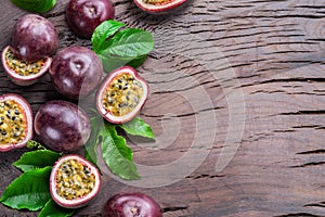 Dark purple passion fruits and it\'s half with seedly interior on wooden table