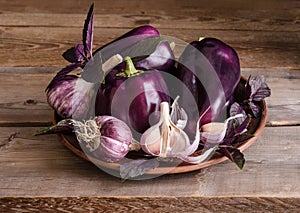 Dark purple peppers with leaves of basil and garlic