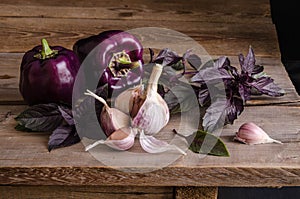 Dark purple peppers with leaves of basil and garlic