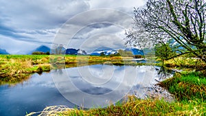 Dark rain clouds on a cold spring day at over the Pitt River and the lagoons of Pitt-Addington Marsh in Pitt Polder at Maple Ridge