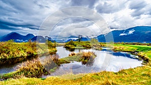 Dark rain clouds on a cold spring day at over the Pitt River and the lagoons of Pitt-Addington Marsh in Pitt Polder at Maple Ridge