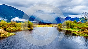 Dark rain clouds on a cold spring day at over the Pitt River and the lagoons of Pitt-Addington Marsh in Pitt Polder at Maple Ridge