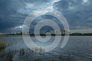 Dark rainy clouds over the lake, May evening