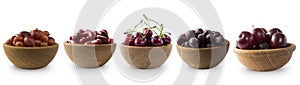 Dark red berries on a white background. Cherries, gooseberries, grapes and plums in a wooden bowl.