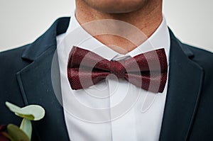 Dark red bowtie on the grooms neck