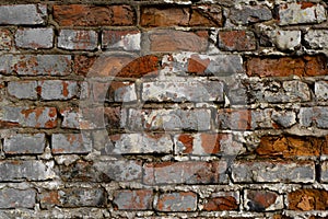 Dark red brick old wall with gray cracked paint, horizontal destroyed brickwork exterior outdoors, close-up. Textured grunge