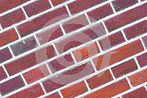 Dark red brick wall background. Photo of a sloping red brick wall