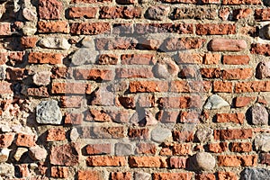 Dark red bricks and small stones wall