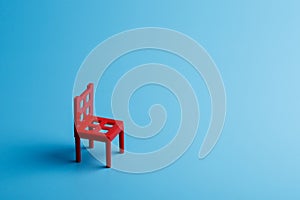 Dark red chair at the edge of the frame on a blue background